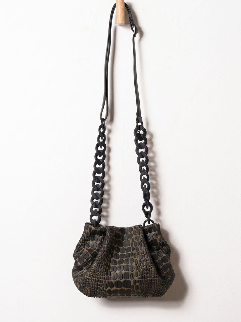 Black textured handbag with chain strap on a white background