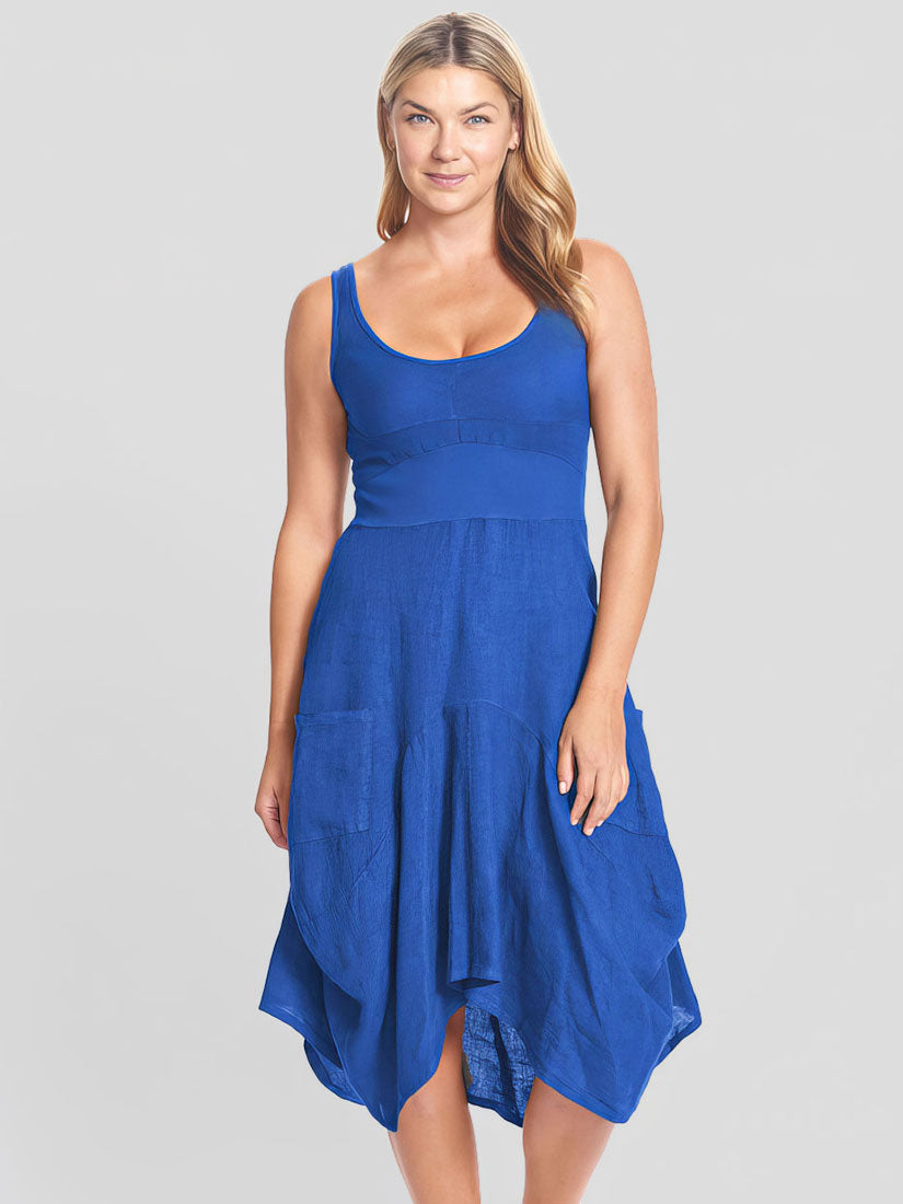 A woman modeling a sleeveless high-low midi dress in a vibrant royal blue color, set against a solid light gray studio background.