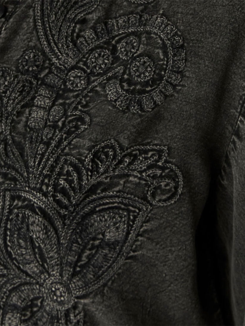 Close-up of a dark charcoal gray fabric with intricate black embroidered paisley and floral patterns.