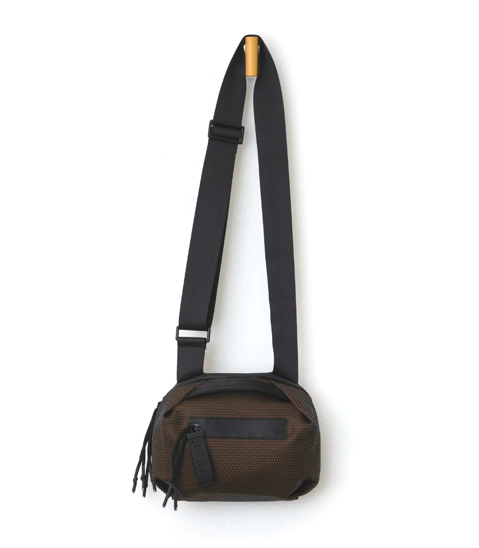 A brown mesh crossbody bag with a black adjustable strap, black zipper, and black leather detail, shown against a plain white background.