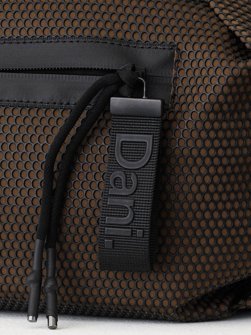 Close-up of a black mesh bag with a black drawstring and a black webbing tag embossed with the brand name 'Dani'.