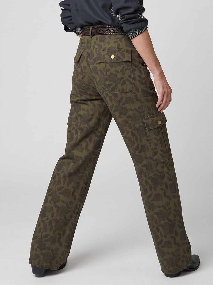 A person wearing olive green cargo pants with a dark grey floral camouflage pattern, shown from the back and side against a light gray studio background.