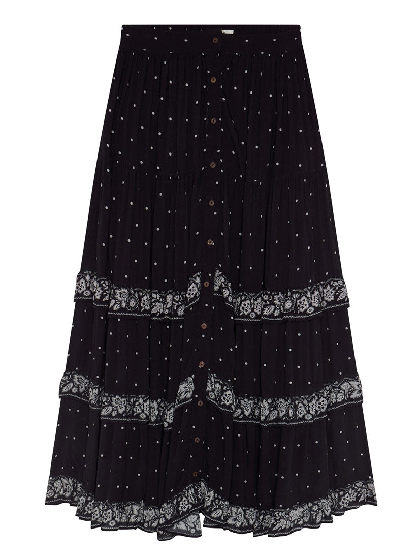 A black tiered skirt with white embroidered dots, lace trim bands, and a button-front closure, shown against a plain white background.