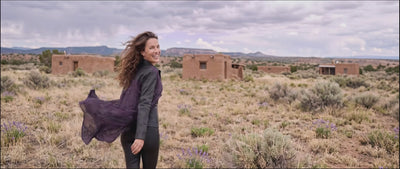 video of woman walking in field in new mexico wearing a lush purple long shirt